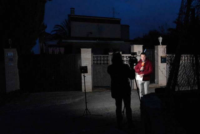 Journalists inform from the entrance to the house where two German citizens were murdered yesterday in Elche, on December 23, 2025. Two German persons were beaten to death in a brawl that got out of hand, Spain's El Pais newspaper reported today, with police saying they had arrested two suspects in the case. The violent scene took place yesterday in a rural area on the Costa Blanca, close to the town of Elche, the regional police service said in a statement to AFP. (Photo by Pablo MIRANZO / AFP)