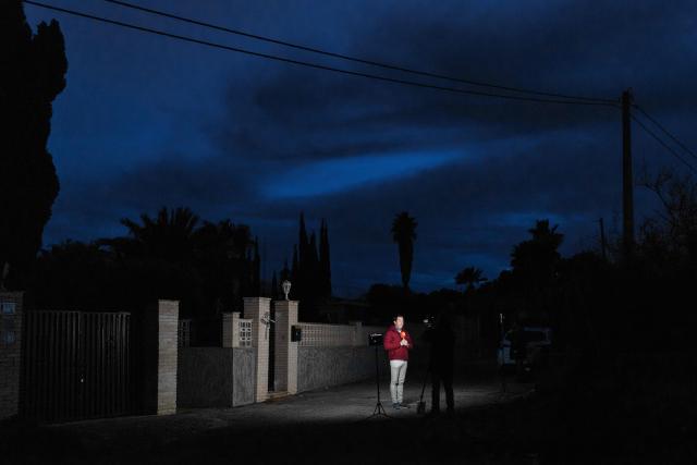 Journalists inform from the entrance to the house where two German citizens were murdered yesterday in Elche, on December 23, 2025. Two German persons were beaten to death in a brawl that got out of hand, Spain's El Pais newspaper reported today, with police saying they had arrested two suspects in the case. The violent scene took place yesterday in a rural area on the Costa Blanca, close to the town of Elche, the regional police service said in a statement to AFP. (Photo by Pablo MIRANZO / AFP)