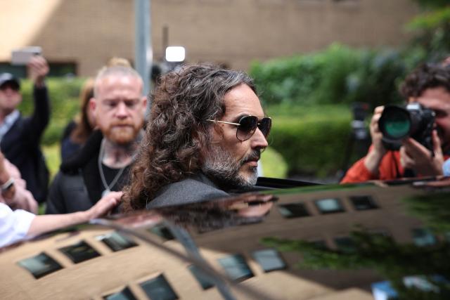 (FILES) British comedian and actor Russell Brand leaves following a hearing at Southwark Crown Court in south London on May 30, 2025. UK police said two new charges, of rape and sexual assault, had been issued on December 23, 2025 against British comedian and actor Russell Brand. (Photo by HENRY NICHOLLS / AFP)