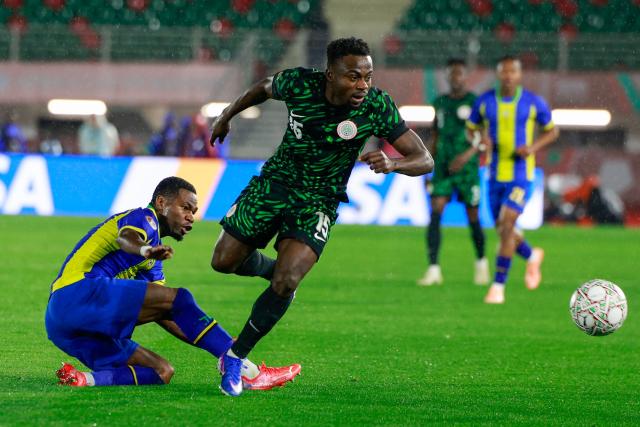 Tanzania's defender #22 Shomari Kapombe and Nigeria's forward #15 Moses Simon vie during the Africa Cup of Nations (CAN) Group C football match between Nigeria and Tanzania at Fez Stadium in Fes on December 23, 2025. (Photo by Abdel Majid BZIOUAT / AFP)