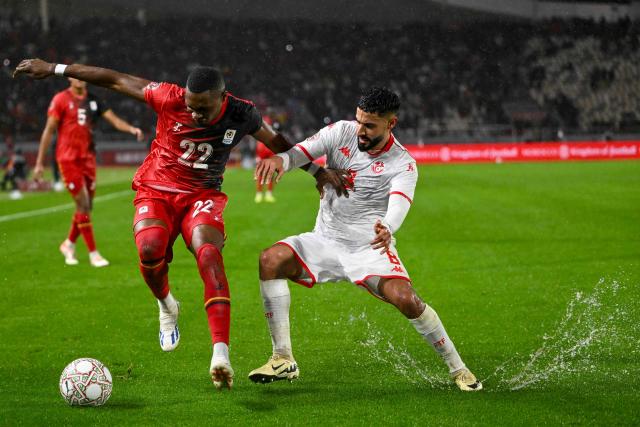 Uganda's forward #22 Jude Ssemugabi and Tunisia's forward #08 Elias Saad vie during the Africa Cup of Nations (CAN) Group C football match between Tunisia and Uganda at Rabat Olympic Stadium in Rabat on December 23, 2025. (Photo by SEBASTIEN BOZON / AFP)