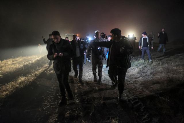 Turkish soldiers evacuate journalists and bystanders from the wreckage site as search and rescue operations are ungoing following the crash of a Libya-bound business jet carrying Libyan Chief of Staff General Muhammad Ali Ahmed Al-Haddad, found 2 kilometers south of Kesikkavak Village at Haymana district in Ankara on December 23, 2025. The head of Libya's armed forces and four other passengers died on December 23, 2025, when their business jet crashed shortly after taking off from Ankara, officials in Turkey's capital and Tripoli said. The wreckage of their Falcon 50 aircraft was located by Turkish security personnel in the Haymana district near Ankara, Turkey's Interior Minister said. (Photo by ADEM ALTAN / AFP)