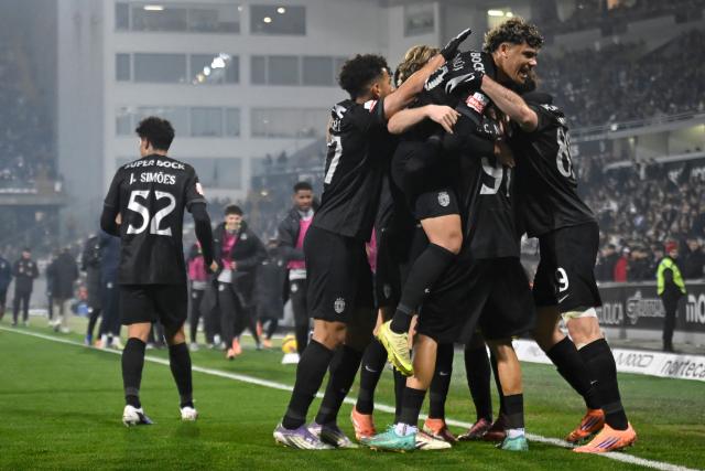 Sporting Lisbon's players celebrate their second goal scored by Sporting Lisbon's Greek forward #89 Fotis Ioannidis during the Portuguese League football match between Vitoria Guimaraes SC and Sporting CP at Dom Afonso Henriques stadium in Guimaraes on December 23, 2025. (Photo by Miguel RIOPA / AFP)