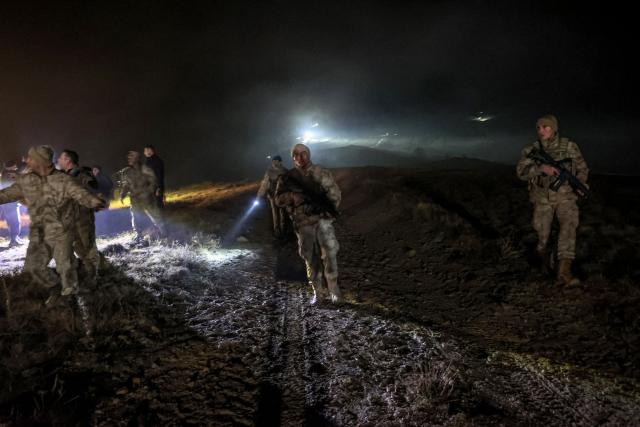Turkish soldiers evacuate journalists and bystanders from the wreckage site as search and rescue operations are ungoing following the crash of a Libya-bound business jet carrying Libyan Chief of Staff General Muhammad Ali Ahmed Al-Haddad, found 2 kilometers south of Kesikkavak Village at Haymana district in Ankara on December 23, 2025. The head of Libya's armed forces and four other passengers died on December 23, 2025, when their business jet crashed shortly after taking off from Ankara, officials in Turkey's capital and Tripoli said. The wreckage of their Falcon 50 aircraft was located by Turkish security personnel in the Haymana district near Ankara, Turkey's Interior Minister said. (Photo by ADEM ALTAN / AFP)
