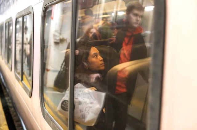 Travelers board a train at Penn Station on December 23, 2025 in New York. (Photo by kena betancur / AFP)