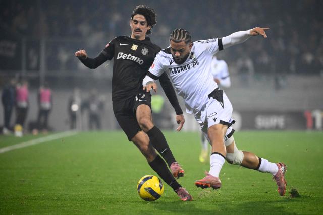 Sporting Lisbon's Portuguese forward #17 Francisco Trincao (L) and Vitoria Guimaraes's Portuguese midfielder # 18 Telmo Arcanjo fight for the ball during the Portuguese League football match between Vitoria Guimaraes SC and Sporting CP at Dom Afonso Henriques stadium in Guimaraes on December 23, 2025. (Photo by Miguel RIOPA / AFP)