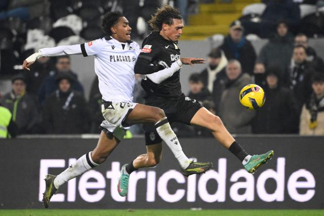 Vitoria Guimaraes's Brazilian defender # 28 Thiago Balieiro and Sporting Lisbon's Portuguese defender #91 Ricardo Mangas fight for the ball during the Portuguese League football match between Vitoria Guimaraes SC and Sporting CP at Dom Afonso Henriques stadium in Guimaraes on December 23, 2025. (Photo by Miguel RIOPA / AFP)