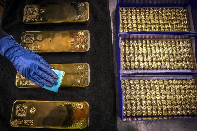 (FILES) A worker polishes gold bullion bars at the ABC Refinery in Sydney on August 5, 2020. Gold prices broke past $4,500 in Asian trade on December 24, 2025 on optimism that the Federal Reserve will continue cutting interest rates next year, and amid rising tensions between the United States and Venezuela. (Photo by DAVID GRAY / AFP)