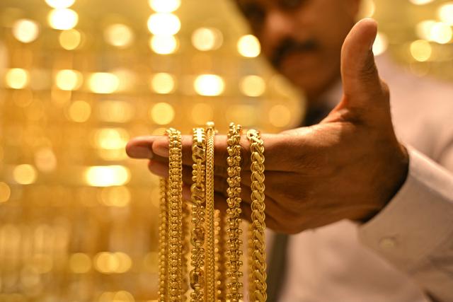 (FILES) A salesman displays gold chains, at Jos Alukkas jewellery store in Bengaluru on September 17, 2025. Gold prices broke past $4,500 in Asian trade on December 24 on optimism that the Federal Reserve will continue cutting interest rates next year, and amid rising tensions between the United States and Venezuela. (Photo by Idrees MOHAMMED / AFP)