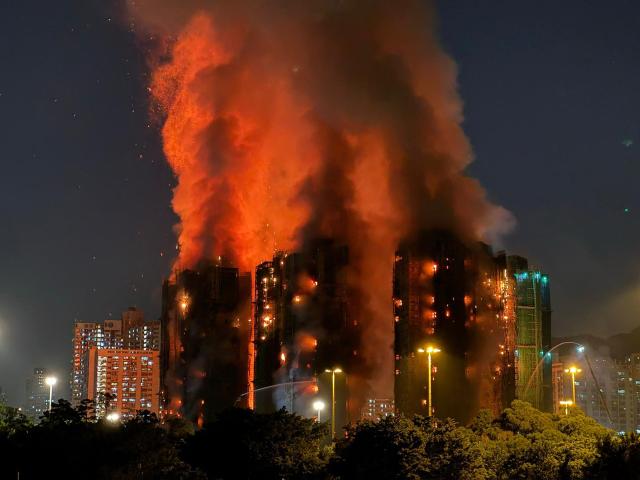 (FILES) Thick smoke and flames rise as a major fire engulfs several apartment blocks at the Wang Fuk Court residential estate in Hong Kong's Tai Po district on November 26, 2025. Thousands are grieving the 161 killed at Wang Fuk Court, a disaster few could imagine happening in one of Asia's safest and most developed cities. Even as the Hong Kong government forges ahead with investigations and relief efforts, experts caution that the psychological scars will be hard to heal for survivors, bereaved families and onlookers alike. (Photo by Yan ZHAO / AFP)