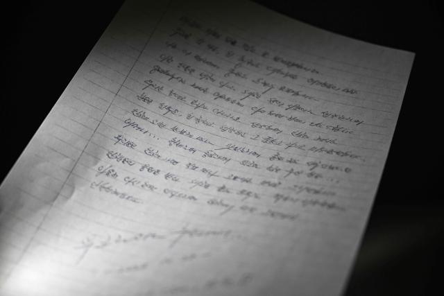 This photo illustration taken in Seoul on December 24, 2025 shows a copy of a letter written on October 28, 2025 by North Korean prisoners of war in Ukraine. Two North Korean prisoners of war held by Ukraine have expressed their desire to start a "new life" in South Korea, according to a letter seen by AFP on December 24. (Photo by Jung Yeon-je / AFP)