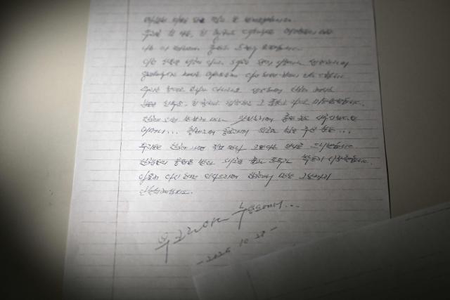 This photo illustration taken in Seoul on December 24, 2025 shows a copy of a letter written on October 28, 2025 by North Korean prisoners of war in Ukraine. Two North Korean prisoners of war held by Ukraine have expressed their desire to start a "new life" in South Korea, according to a letter seen by AFP on December 24. (Photo by Jung Yeon-je / AFP)