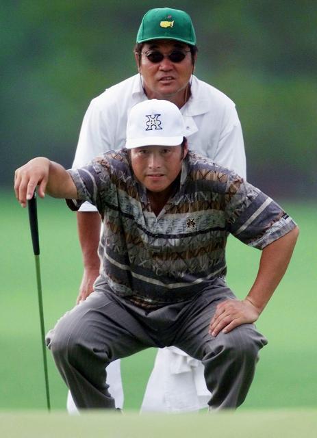 (FILES) Masashi "Jumbo" Ozaki  of Japan lines up his putt with his caddie Kazushi Sanogi (rear) on the 14th hole during the first round of the Masters golf tournament at the Augusta National Golf Club in Augusta, Georgia, on April 8, 1999. Japanese star Masashi "Jumbo" Ozaki, inducted into the World Golf Hall of Fame in 2011, has died of colon cancer, his son announced on December 24, 2025. He was 78. (Photo by ROBERTO SCHMIDT / AFP)