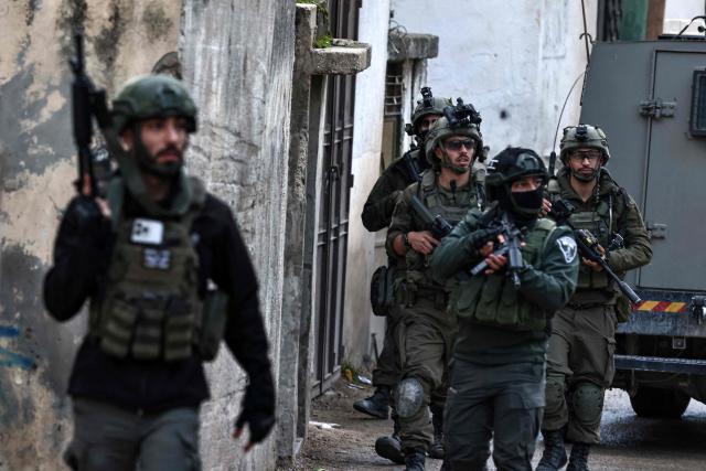 Israeli security forces secure a street as they leave the Palestinian village of Bizariya, in the occupied West Bank, where Israeli authorities demolished the house of a Palestinian man killed in July after he and another man reportedly killed an Israeli settler on the same day, on December 24, 2025. (Photo by Zain JAAFAR / AFP)