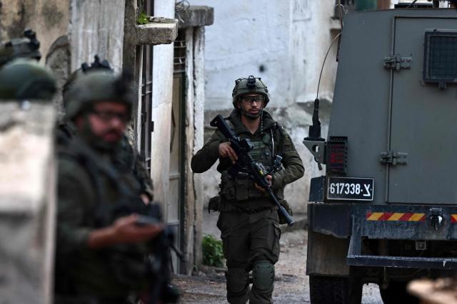 Israeli security forces secure a street as they leave the Palestinian village of Bizariya, in the occupied West Bank, where Israeli authorities demolished the house of a Palestinian man killed in July after he and another man reportedly killed an Israeli settler on the same day, on December 24, 2025. (Photo by Zain JAAFAR / AFP)