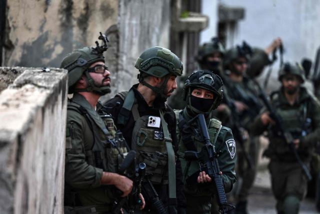 Israeli security forces secure a street as they leave the Palestinian village of Bizariya, in the occupied West Bank, where Israeli authorities demolished the house of a Palestinian man killed in July after he and another man reportedly killed an Israeli settler on the same day, on December 24, 2025. (Photo by Zain JAAFAR / AFP)