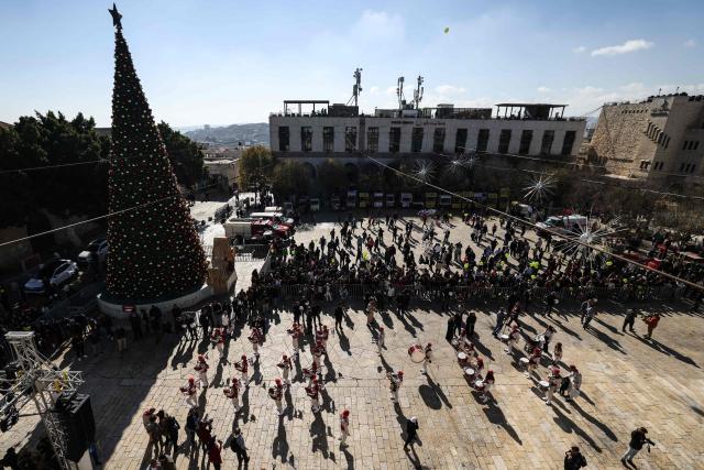 Members of the scouting movement march during Christmas eve celebrations at the Manger Square outside the Church of the Nativity in Bethlehem, in the Israeli-occupied West Bank, on December 24, 2025. (Photo by HAZEM BADER / AFP)