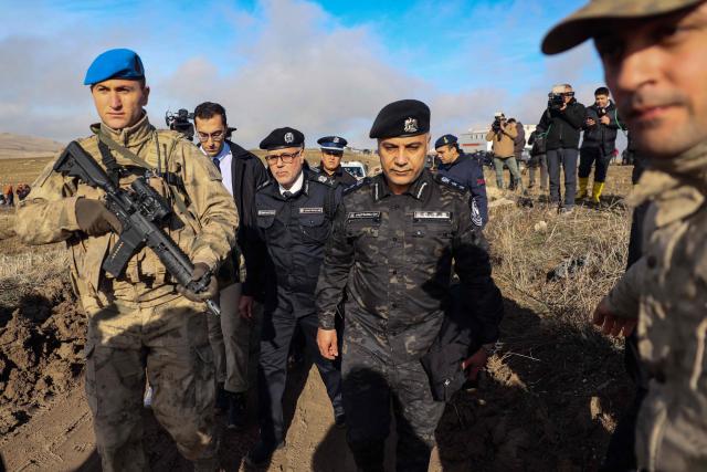 Libyan military delegation members arrive at the wreckage site following the crash of a Libya-bound business jet carrying Libyan Chief of Staff General Muhammad Ali Ahmed Al-Haddad, found 2 kilometers south of Kesikkavak Village at Haymana district in Ankara on December 24, 2025. The head of Libya's armed forces and four other passengers died on Tuesday when their business jet crashed shortly after taking off from Ankara, officials in Turkey's capital and Tripoli said. The wreckage of their Falcon 50 aircraft was located by Turkish security personnel in the Haymana district near Ankara, Turkey's Interior Minister said. (Photo by ADEM ALTAN / AFP)