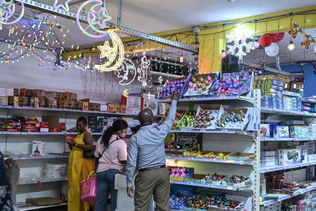 People buy Christmas decorations in a toy store in Abidjan on December 23, 2025 ahead of Christmas. (Photo by Sia KAMBOU / AFP)
