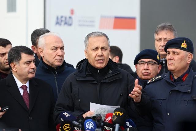 Turkey's Interior Minister Ali Yerlikaya (C) speaks to the media at the wreckage site following the crash of a Libya-bound business jet carrying Libyan Chief of Staff General Muhammad Ali Ahmed Al-Haddad, found 2 kilometers south of Kesikkavak Village at Haymana district in Ankara on December 24, 2025. The head of Libya's armed forces and four other passengers died on Tuesday when their business jet crashed shortly after taking off from Ankara, officials in Turkey's capital and Tripoli said. The wreckage of their Falcon 50 aircraft was located by Turkish security personnel in the Haymana district near Ankara, Turkey's Interior Minister said. (Photo by Adem ALTAN / AFP)
