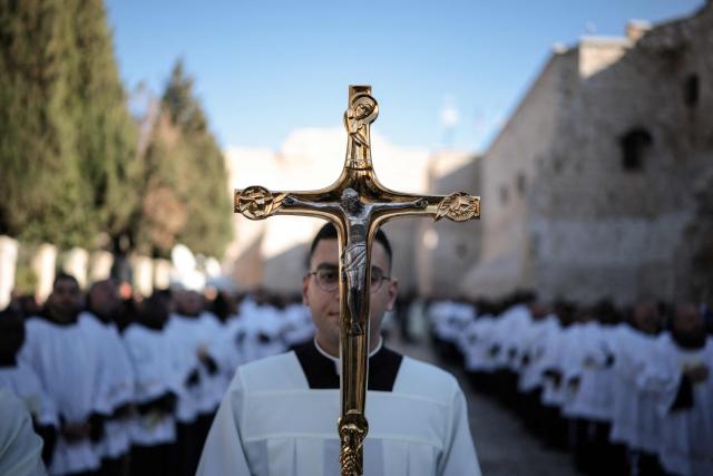 Members of the clergy take part in the yearly Christmas procession led by Latin Patriarch of Jerusalem outside the Church of the Nativity in the Israeli-occupied West Bank city of Bethlehem  on December 24, 2025. Scouts marched under a clear blue sky in Bethlehem on December 24, 2025, as the Palestinian city emerged from the shadow of the war in Gaza to celebrate its first festive Christmas in more than two years. Throughout the Gaza war that began with Hamas's attack on Israel in October 2023, a sombre tone marked Chistmases in Bethlehem, the biblical birthplace of Jesus Christ. (Photo by ilia yefimovich / AFP)