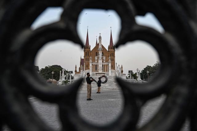 Police personnel stand guard outside the Saint Patrick's Cathedral on Christmas Eve in Karachi on December 24, 2025. (Photo by Rizwan TABASSUM / AFP)