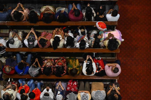 Christian devotees pray during a Christmas Eve mass at the St. Mary’s Cathedral in Yangon on December 24, 2025. (Photo by Sai Aung MAIN / AFP)