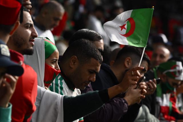 An Algeria supporter waves a flag ahead of the Africa Cup of Nations (CAN) Group E football match between Algeria and Sudan at Moulay Hassan Stadium in Rabat on December 24, 2025. (Photo by SEBASTIEN BOZON / AFP)
