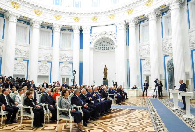 In this pool photograph distributed by the Russian state agency Sputnik, Russia's President Vladimir Putin gives a speech during a state awards ceremony at the Kremlin in Moscow on December 24, 2025. (Photo by Mikhail METZEL / POOL / AFP)