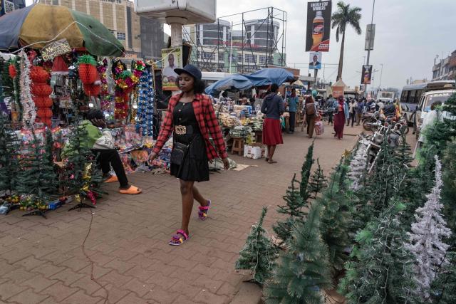 Vendors display Christmas merchandise and other goods as they wait for customers along a busy commercial street in Kampala on December 24, 2025, on Christmas eve. (Photo by Badru KATUMBA / AFP)