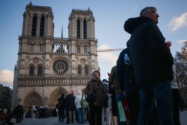 Visitors queue to enter the Notre Dame Cathedral in central Paris on Christmas eve, December 24, 2025. (Photo by Dimitar DILKOFF / AFP)