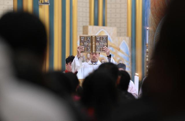 Members of the Catholic clergy and devotees attend the Christmas Eve mass at the Xishiku Church in Beijing on December 24, 2025. (Photo by Adek BERRY / AFP)