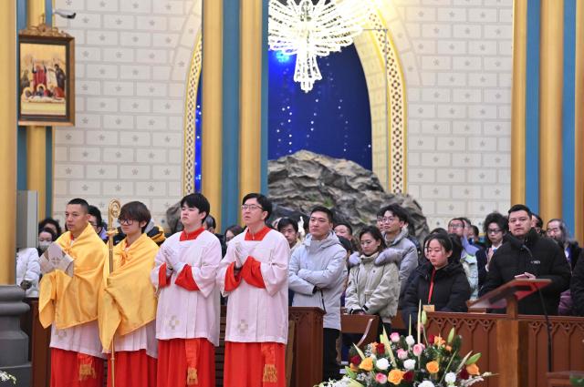 Members of the Catholic clergy and devotees attend the Christmas Eve mass at the Xishiku Church in Beijing on December 24, 2025. (Photo by Adek BERRY / AFP)