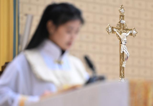 A member of the Catholic clergy attends the Christmas Eve mass at the Xishiku Church in Beijing on December 24, 2025. (Photo by Adek BERRY / AFP)