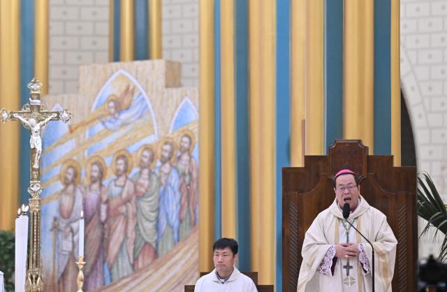 A priest delivers a sermon during the Christmas Eve mass at the Xishiku Church in Beijing on December 24, 2025. (Photo by Adek BERRY / AFP)