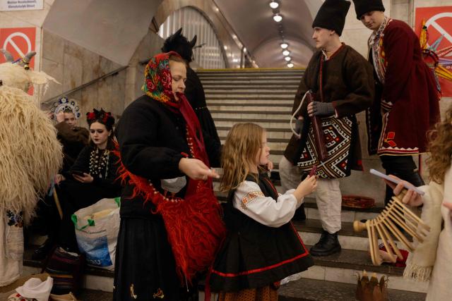 Participants of nativity scene, Vertep in Ukraine, adjust their costumes before performing in the subway in Kyiv on December 24, 2025, amid the Russian invasion of Ukraine. (Photo by Tetiana DZHAFAROVA / AFP)