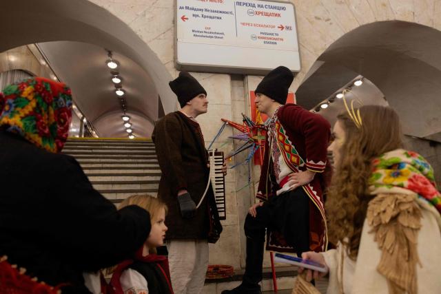 Participants of nativity scene, Vertep in Ukraine, adjust their costumes before performing in the subway in Kyiv on December 24, 2025, amid the Russian invasion of Ukraine. (Photo by Tetiana DZHAFAROVA / AFP)
