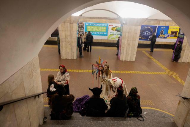Participants of nativity scene, Vertep in Ukraine, adjust their costumes before performing in the subway in Kyiv on December 24, 2025, amid the Russian invasion of Ukraine. (Photo by Tetiana DZHAFAROVA / AFP)
