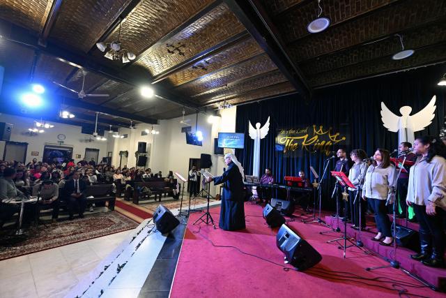 Emmanuel Gharib, Chairman of the National Evangelical Church Kuwait and Pastor of the Kuwait Presbyterian Church, leads a Christmas mass at a church in Kuwait City on December 24, 2025. (Photo by YASSER AL-ZAYYAT / AFP)