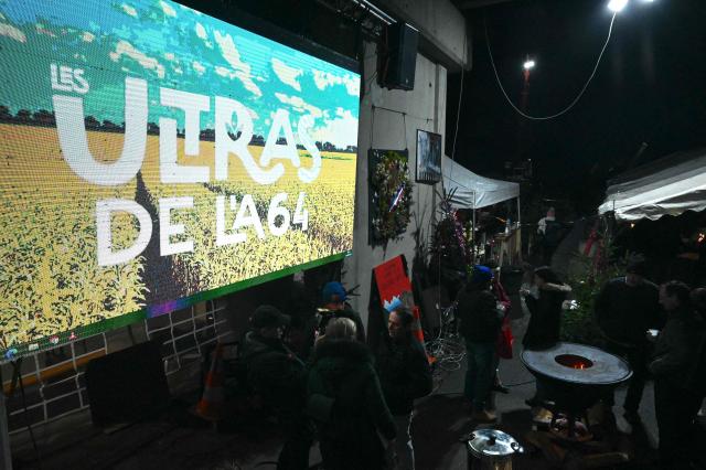 Farmers gather to celebrate Christmas Eve on the A64 motorway during a farmers blockade to protest against the government's mandatory culling protocol for cattle herds affected by lumpy skin disease (dermatose nodulaire contagieuse), in Carbonne, south-western France, on December 24, 2025. (Photo by Matthieu RONDEL / AFP)