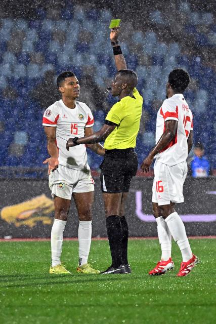 Mozambique's defender #15 Reinildo Mandava (L) receives a yellow card during the Africa Cup of Nations (CAN) Group F football match between Ivory Coast and Mozambique at Marrakesh Stadium in Marrakesh on December 24, 2025. (Photo by Khaled DESOUKI / AFP)