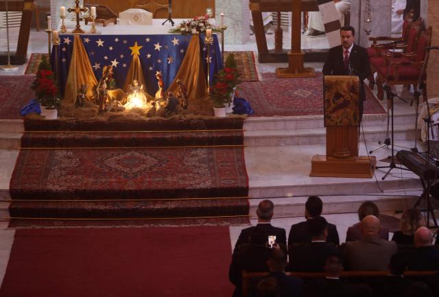 Iraqi Prime Minister Mohammed Shia al-Sudani speaks with Christians celebrating the birth of Jesus Christ during the Christmas Eve Mass at Our Lady of Salvation Church in Baghdad on December 24, 2025. (Photo by AHMAD AL-RUBAYE / AFP)