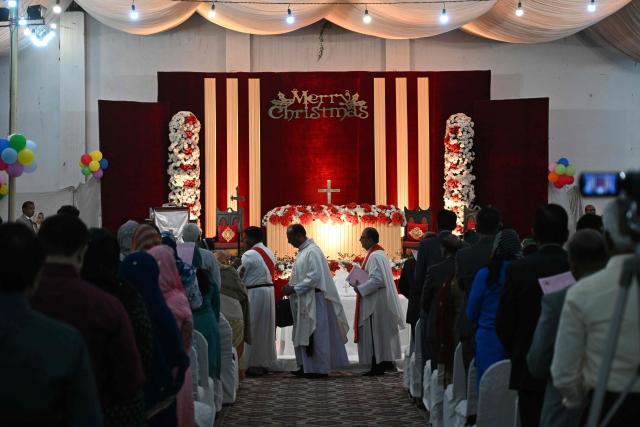 Christian devotees attend a midnight Christmas mass on Christmas Eve at the Central Brooks Memorial Church in Karachi on December 24, 2025. (Photo by Rizwan TABASSUM / AFP)