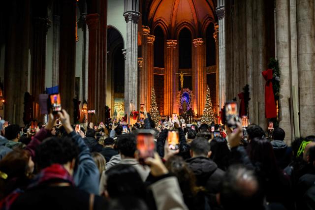 Devotees attend a Christmas Eve mass at the Saint Antuan church, the largest Roman Catholic Church in Istanbul, on December 24, 2025. (Photo by Yasin AKGUL / AFP)
