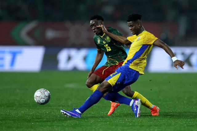Gabon's midfielder #22 Didier Ndong (R) gets the ball past Gabon's midfielder #15 Samake Nze Bagnama during the Africa Cup of Nations (CAN) Group F football match between Cameroon and Gabon at Adrar Stadium in Agadir on December 24, 2025. (Photo by FRANCK FIFE / AFP)