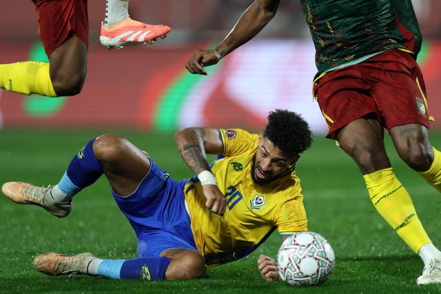 TOPSHOT - Gabon's forward #20 Denis Bouanga is tackled by Cameroon's defender #17 Samuel Kotto during the Africa Cup of Nations (CAN) Group F football match between Cameroon and Gabon at Adrar Stadium in Agadir on December 24, 2025. (Photo by FRANCK FIFE / AFP)