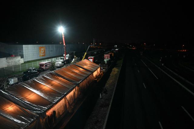 This photograph shows a tent on a side of the blockaded A64 motorway as farmers attend a Christmas Eve mass during a farmers blockade to protest against the government's mandatory culling protocol for cattle herds affected by lumpy skin disease (dermatose nodulaire contagieuse), in Carbonne, south-western France, on December 24, 2025. (Photo by Matthieu RONDEL / AFP)
