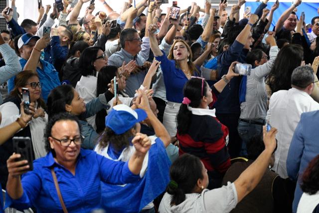 Supporters of Honduras' presidential candidate Nasry Asfura of the National Party celebrate after the National Electoral Council (CNE) declares him the winner of the Honduras Presidential Election in Tegucigalpa on December 24, 2025. Conservative businessman Nasry Asfura, backed by US President Donald Trump, was officially proclaimed the new president of Honduras on December 24, 2025, three weeks after an election marked by a narrow margin of victory and allegations of fraud. (Photo by Orlando SIERRA / AFP)
