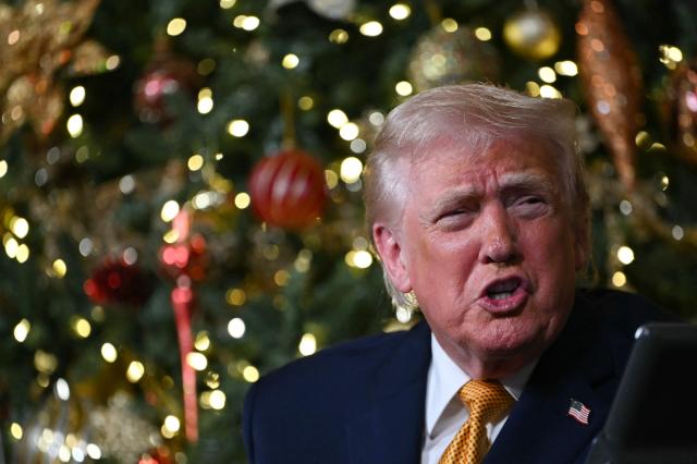 US President Donald Trump participates in NORAD Santa tracker phone calls, on Christmas Eve, from the Mar-a-lago club in Palm Beach, Florida, on December 24, 2025. (Photo by ANDREW CABALLERO-REYNOLDS / AFP)