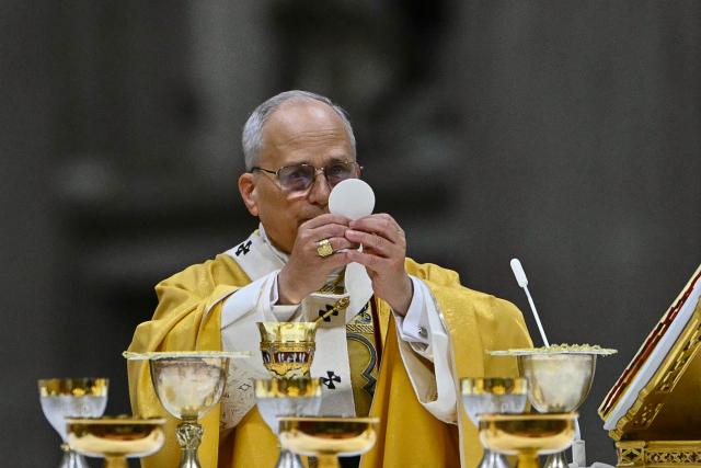 Pope Leo XIV carries out communion as he performs the Christmas Eve mass at St Peter's Basilica in the Vatican on December 24, 2025. (Photo by Andreas SOLARO / AFP)